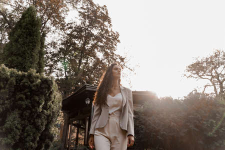 Smiley girl in the green park. Happy young woman walks around green garden. Lifestyle of young business woman.の写真素材