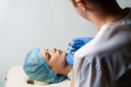 Filler injection of hyaluronic acid. Contour plastic for correcting the volume and shape of the nose, chin, cheekbones, temples. Cosmetic rejuvenating facial treatment in medical clinicの写真素材