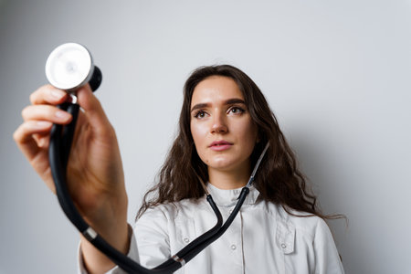 Medical student girl doing auscultation to patient. Doctor uses phonendoscope for auscultation....