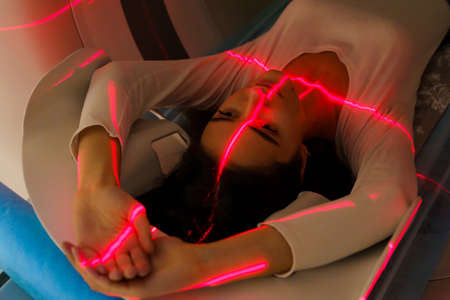 Red rays scan a girl on computed tomographyの写真素材