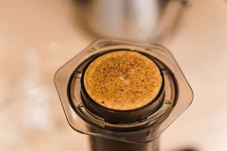 Coffee aeropress creams close-up. Alternative coffee brewing method. Aeropress device on the table. Advert for social networks of restaurants, cafe.の写真素材