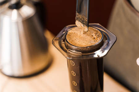 Aeropress coffee close-up alternative making by barista in the cafe. Scandinavian coffee brewing method. Barista mix coffee in aeropress. Advert for cafe, restaurants.の写真素材