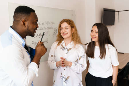 Multiethnic happy students and black teacher study foreign languages and smile and laught together...