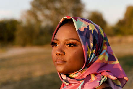 Close up african black woman weared in scarf named hijab looking left side. Portrait of muslim woman with closed eyes. African nationality.の写真素材