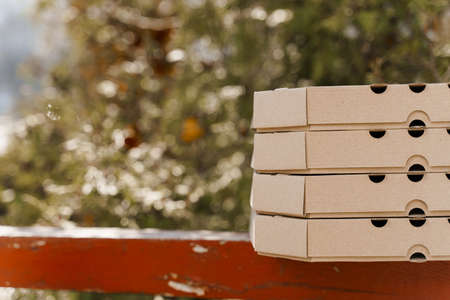 Promotion of 2 + 2 pizza boxes for food delivery. Isolated photo of 4 cardboard pizza boxes with...