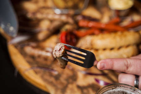 Barbecue grilled hot dog with yellow mustard and ketchup on wooden background. Hot dog sandwich with potato fries and sauces.の写真素材