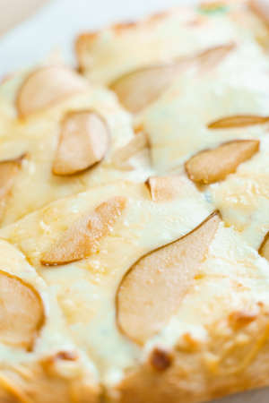 Pinsa romana with pear, cheese, prosciutto in delivery box. Scrocchiarella gourmet italian cuisine on white background. Holding traditional dish. Food delivery from pizzeria.の写真素材