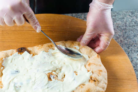 Chef cooking pinsa romana with pear, cheese, prosciutto in delivery box. Scrocchiarella gourmet...