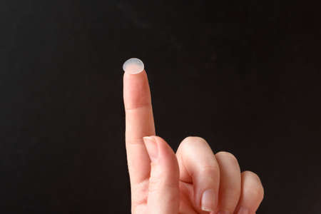 Round patches for acne and wrinkles on the finger on a white background. Acne and wrinkle patches...