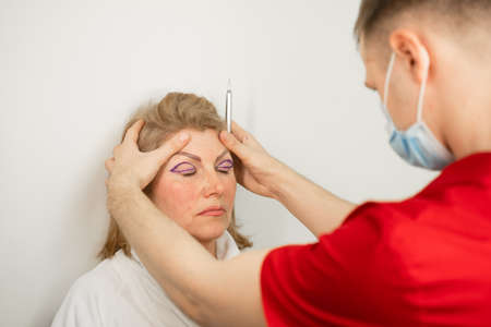 Blepharoplasty markup close-up on the face before the plastic surgery operation for modifying the...