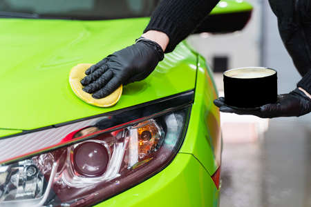 Hard wax for protection paintwork of car using sponge for remove paint scratches. Applying hard wax...