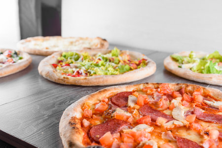 Assortment of pizza with meat, salami, prosciutto, tomatoes, dorblu cheese, mozzarella, parmesan,...