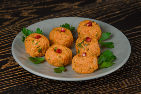 Carrot pkhali decorated with parsley and pomegranate. Georgian appetizer on a gray plate on a dark wooden table.の写真素材