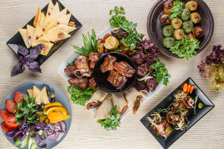 Assortment of grilled meat, Georgian cuisine snacks, cheese, vegetable cuts on a white wooden table. Top viewの写真素材