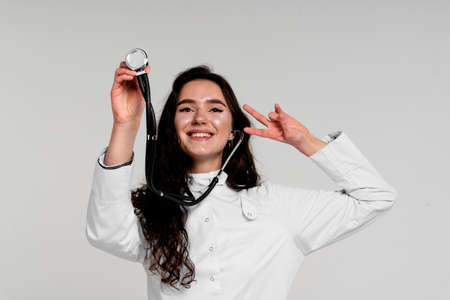 Doctor in medical robe with stethoscope at coronavirus covid-19 period. Nurse in white medical dress on white backgroundの写真素材