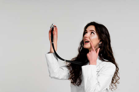 Doctor in medical robe with stethoscope at coronavirus covid-19 period. Nurse in white medical dress on white backgroundの写真素材