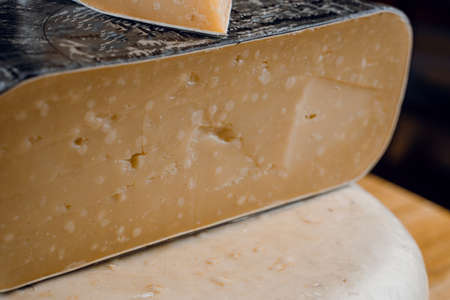 Goat cheese wheel and big pieces of it. Mix of cheeses from goat milk.の写真素材