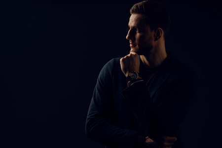 Business man portrait on dark background. Handsome young man weared suit in studio. Confident professional fashion male posing in studio.の写真素材