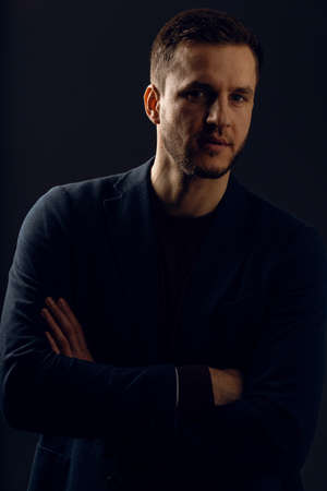 Confident professional fashion male posing in studio. Business man portrait on dark background....