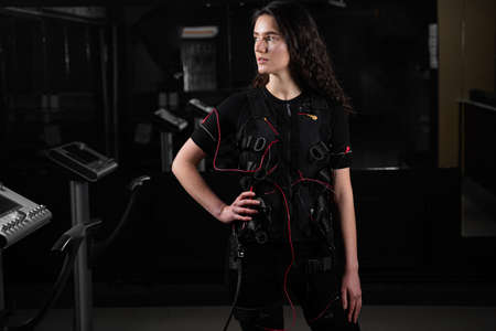 Girl in EMS suit in gym. Sport training in electrical muscle stimulation suitの写真素材