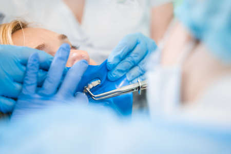 Dental treatment cofferdam in stomatology. Dentist using dental dam for tooth isolation