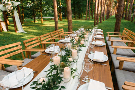 Rustic green branch and candles on the table. Wedding decorationの写真素材