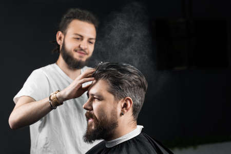 Barber making hairstyle for confident bearded hipster. Advertising for barbershop and men's beauty...