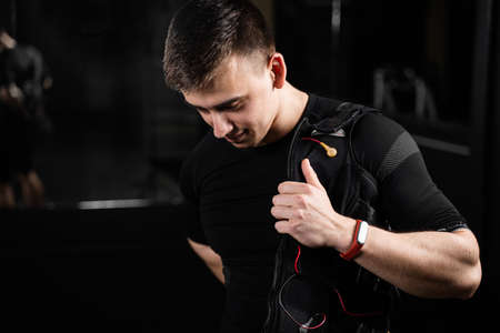 Wearing EMS suit in gym. Sport training in electrical muscle stimulation suitの写真素材