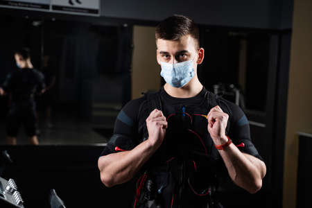 Man in EMS suit and medical mask in gym.の写真素材