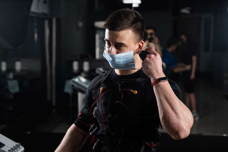 Man in EMS suit and medical mask in gym.の写真素材