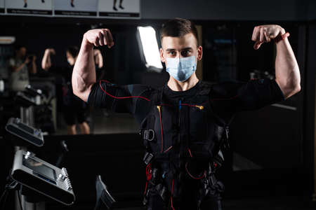 Man in EMS suit and medical mask in gym.の写真素材