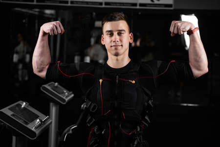 Muscular man trainer weared ems electrical body suit in gym. electro impulse stimulation with contactors on suitの写真素材