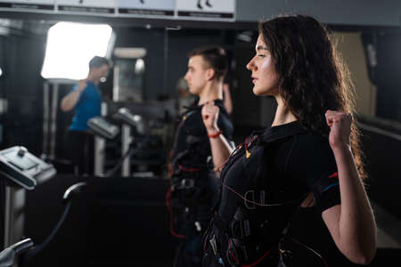 EMS group training for two men and women in the gym. Electrical stimulation for muscles of body
