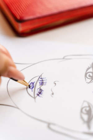 Beautician drawing zone of mimic activity in the patient chart in the cosmetology office.の写真素材