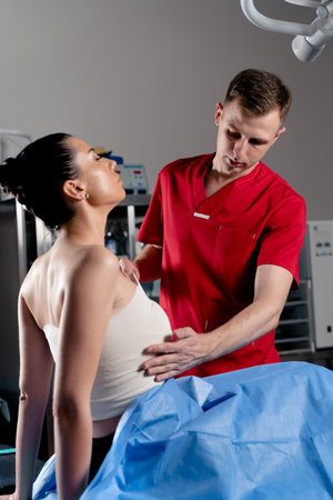 Surgeon with woman patient in operating room before breast augmentation for girl. Doctor wraps around the patient chest after breast augmentation.の写真素材