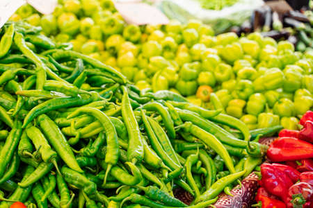 Mix of chili peppers, bell peppers, capi color assortment on vegetable marketの写真素材