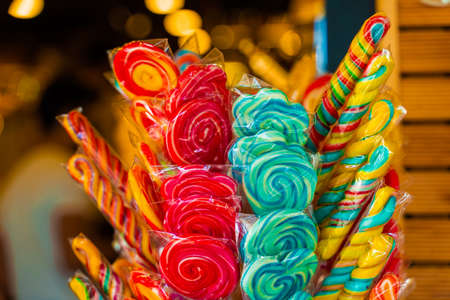 Caramel colored lollipops for children on sticks at entrance to market.の写真素材