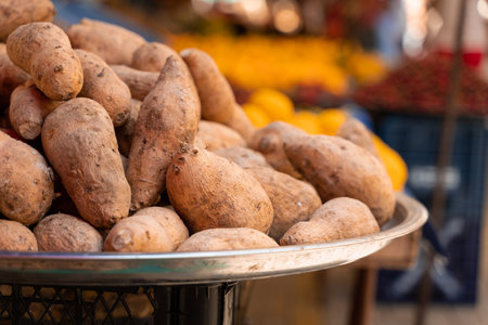 Sweet potatoes named batata on counter market on background of lemonsの写真素材