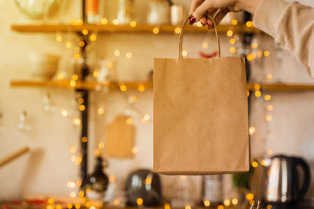 Craft bag for shopping at new year eve. Bag on christmas lights background. New year sale.の写真素材