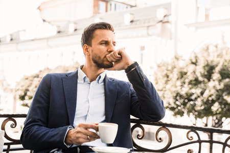 Handsome man with cup of coffee in cafe. Morning lifestyle of maleの写真素材