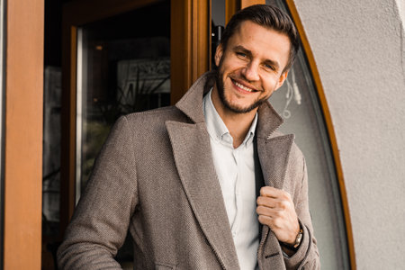Handsome bearded business man in coat posing outside. Male lifestyleの写真素材