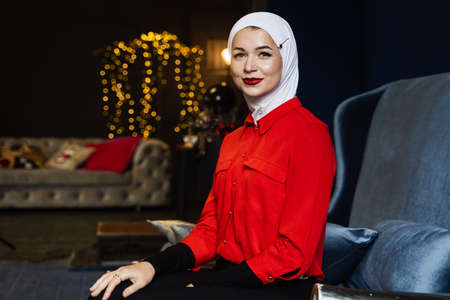 Muslim woman near christmas decoration in studio. Professional muslim model posing at the new year...
