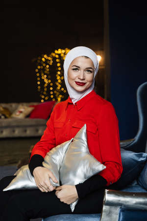 Muslim woman near christmas decoration in studio. Professional muslim model posing at the new year...