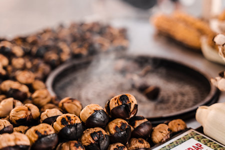 Process of roasting chestnuts on pan. Grilled chestnut snack food on the street market.の写真素材