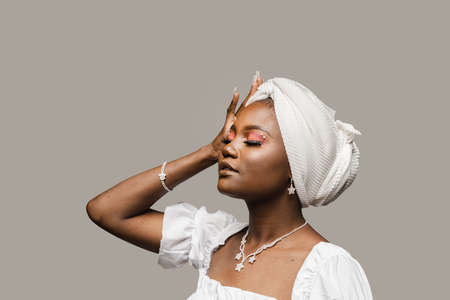 Beauty portrait of muslim woman weared white dress and headscarf on gray background. Softness and wellness of body and skinの写真素材