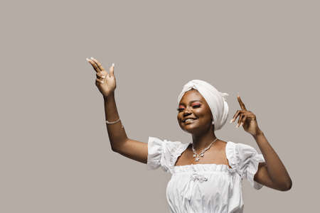 Black muslim woman is putting her hands up and dance and party. African girl is celebrating her...