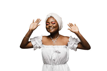 Black muslim woman is putting her hands up and dance and party. African girl is celebrating her birthday and having funの写真素材