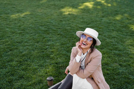Fashion model weared white posing on the grass. Lifestyle portraitの写真素材