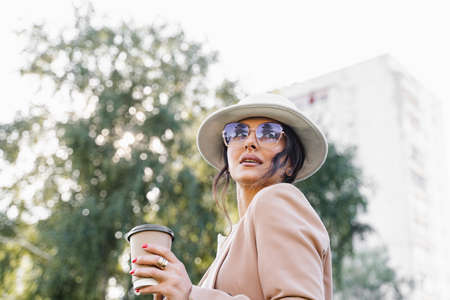 Close-up portrait of business lady is drinking coffee outdoor in the parkの写真素材