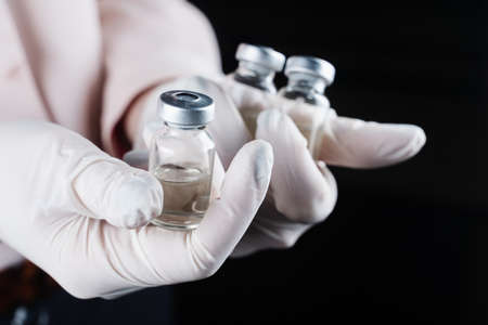 3 virus booster vaccines in hands in medical gloves. vaccination